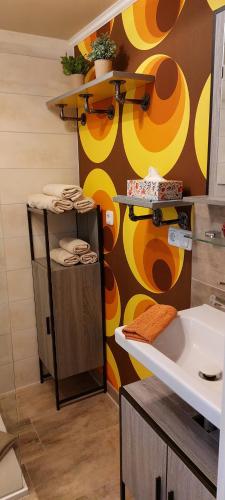 a bathroom with a sink and a yellow and brown wall at Ferienhaus Wald-Idyll Meisdorf in Meisdorf