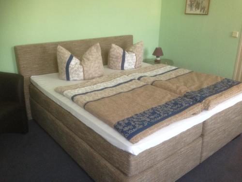 a large bed with pillows on it in a room at Gasthof & Pension Zum Saalestrand in Bad Dürrenberg