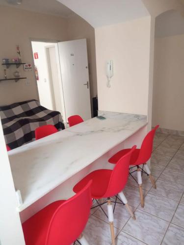 a room with a white table and red chairs at Apartamento in Solemar