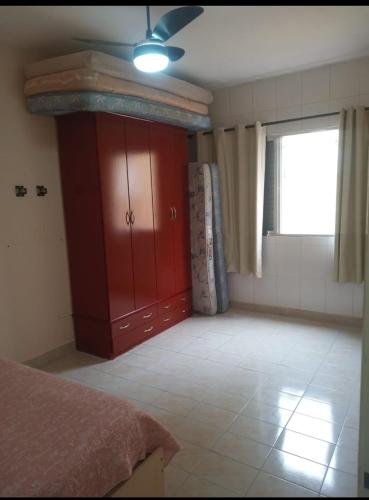 a bedroom with a red cabinet and a window at Apartamento in Solemar