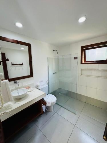 a bathroom with a toilet and a sink and a shower at Pousada Coisa e Tao in Arraial d'Ajuda