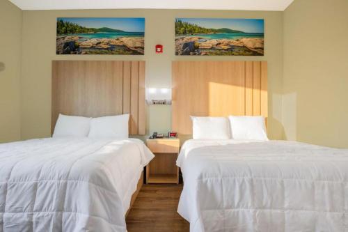 two beds sitting next to each other in a room at Royal Inn & Suites in Adairsville