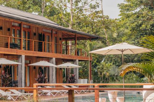 a resort with tables and umbrellas in front of it at S Boutique Hotel in Bocas del Toro