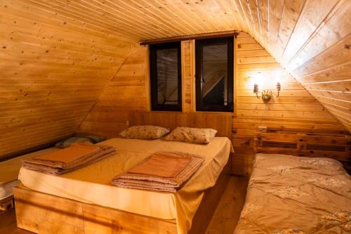 a bedroom with two beds in a log cabin at Edgar's House in Bnunis