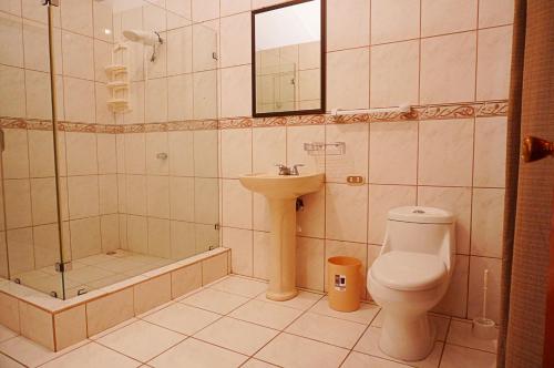 a bathroom with a toilet and a sink and a shower at Quinta Playa Blanca in Punta Leona