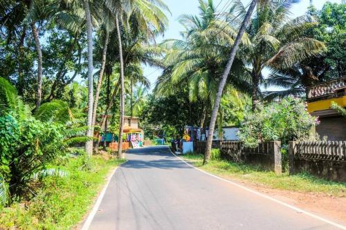 a street with palm trees on the side of a road at Seacoast Retreat varca in Varca