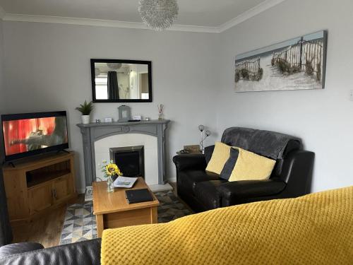 a living room with a couch and a tv at SeasideEscape-2Br-Sleeps4-Parking-PetsOK-Fireplace in Bridlington