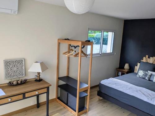 - une chambre avec un lit et un bureau à côté d'un lit dans l'établissement Les Isatis, à Montarnaud