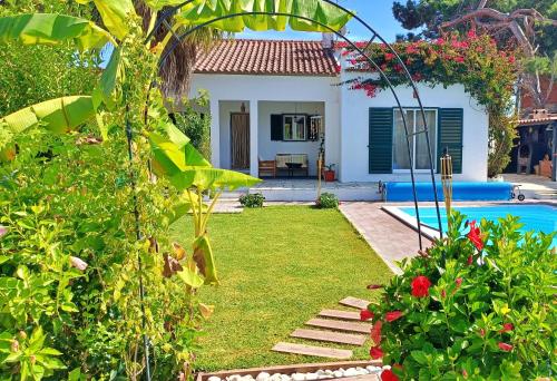a garden with a house and a swimming pool at A Casa da Lagoa de Albufeira in Sesimbra