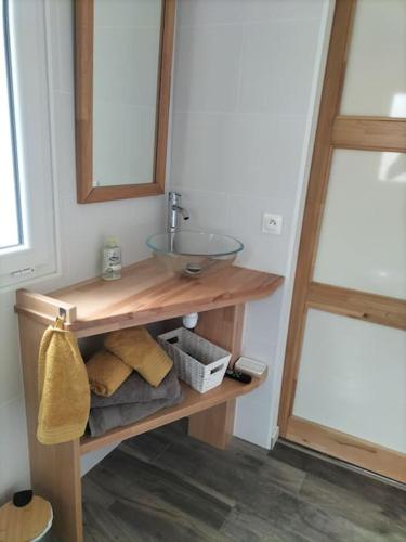 une salle de bain avec un lavabo et une étagère avec des serviettes dans l'établissement Logement entier, à Mazières-en-Gâtine