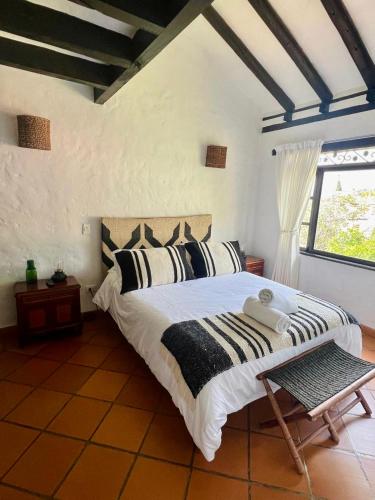 a bedroom with a large bed with black and white pillows at Pancha Mama Hotel Boutique in Villa de Leyva