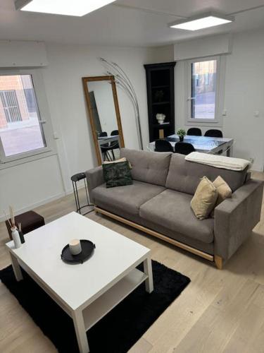 un salon avec un canapé et une table dans l'établissement Confort et charme aux Arcades, à Montigny-le-Bretonneux