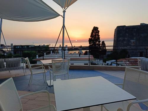 a patio with tables and chairs and a sunset at Eden Bleu in Vico Equense