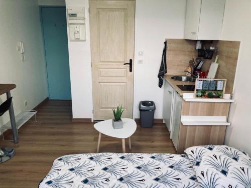 a small room with a bed and a table and a kitchen at Parlementaire européen, waken schiltigheim in Schiltigheim