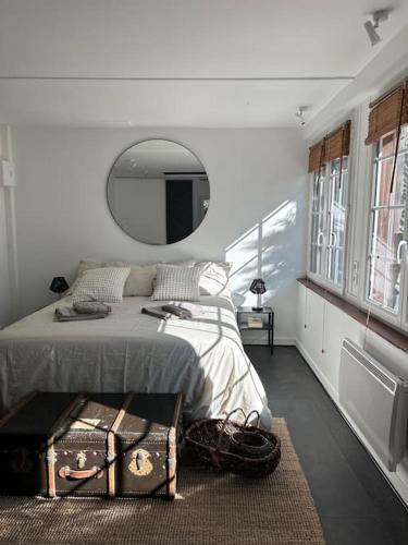 - une chambre avec un lit et un grand miroir dans l'établissement Le petit cocon de Breuilpont, à Breuilpont