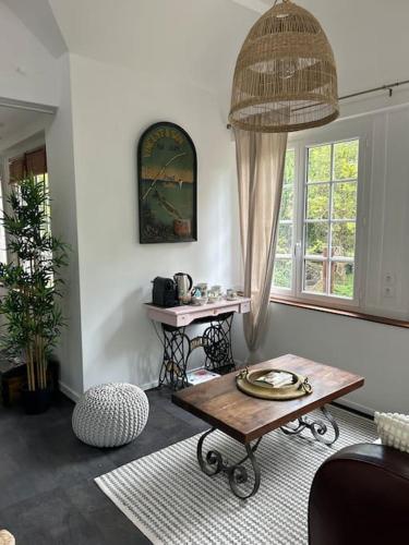 un salon avec une table et une fenêtre dans l'établissement Le petit cocon de Breuilpont, à Breuilpont