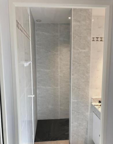 une douche avec une porte vitrée dans une salle de bain dans l'établissement Le Bastidon de L Olivier, à Gordes