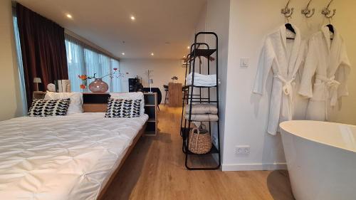 a bedroom with a bed and a sink and a tub at Studio in Amsterdam Area Horizon Hideaway in Broek in Waterland
