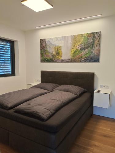 Una cama en un dormitorio con un cuadro en la pared. en Wohlfühl-Ferienwohnung "Igelnest", en Vorderelsenwang