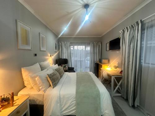 a bedroom with a large white bed and a window at Cozy Hide in East London