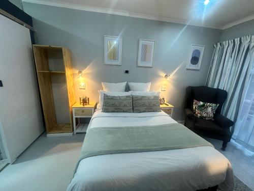 a bedroom with a large bed and a chair at Cozy Hide in East London