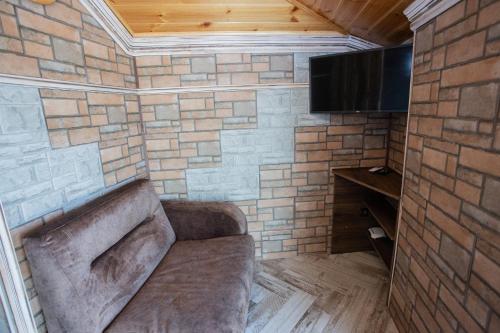 a living room with a couch and a tv at Къща за гости ANGELOVI in Veliko Tŭrnovo
