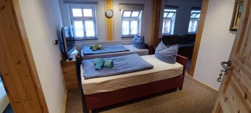 two twin beds in a room with a clock on the wall at Ferienwohnung Leon in Heldburg