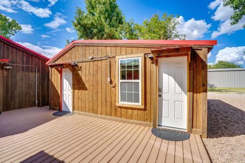 a wooden shed with a white door on a deck at Lakefront Graford Home with Fire Pit and Private Dock! in Graford