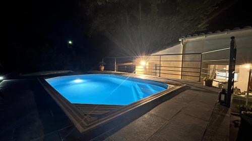 une piscine la nuit avec des lumières dessus dans l'établissement Villa Simone proche Uzes, à Blauzac