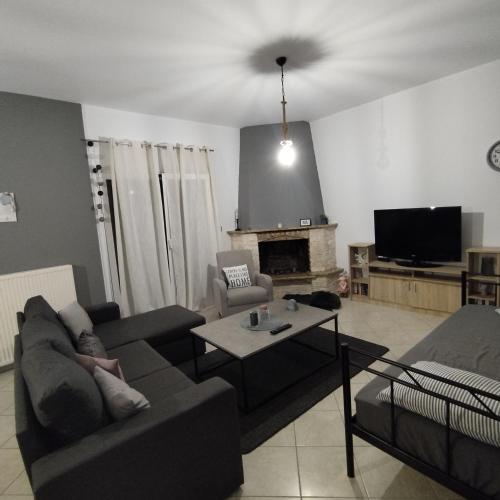 a living room with two couches and a tv at Mary's Home in Asproklissi