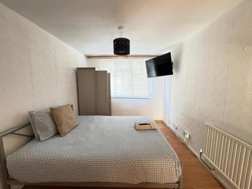 a bedroom with a bed and a television on the wall at PRP Pennack Road Peckham London in London
