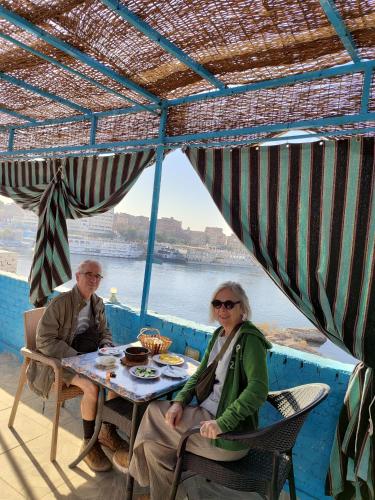 two people sitting at a table under an umbrella at Jamaica Guest House in Aswan
