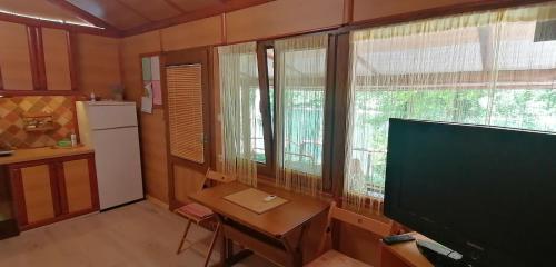 a room with a television and a table and a refrigerator at Kucerak na Drini in Bajina Bašta