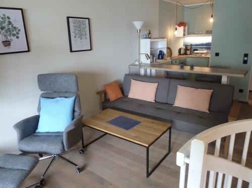 een woonkamer met een bank en een tafel bij Große FeWo-Suite "Nordstern" in direkter Seelage, mit Kanu in Ascheberg