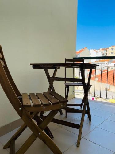 a wooden table and a chair sitting on a balcony at Graceful 1 Bedroom Apartament - G203 in Lisbon
