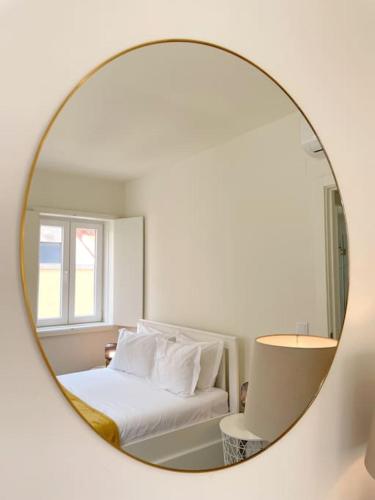 a mirror reflecting a bedroom with a bed and a window at Graceful 1 Bedroom Apartament - G203 in Lisbon