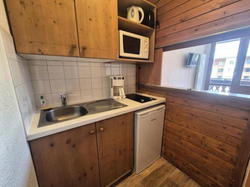 une petite cuisine avec un évier et un micro-ondes dans l'établissement Résidence Rond Point Des Pistes C - Studio·Proche des pistes·Balcon MAE-7584, à Tignes