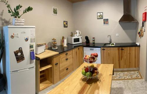 a kitchen with a bowl of fruit on a table at Casa Emília & Alda in Juncal