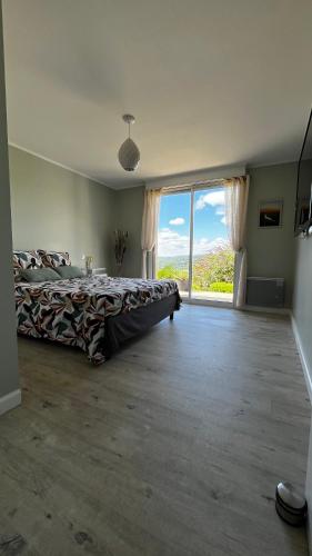 - une grande chambre avec un lit et une grande fenêtre dans l'établissement Maison belle vue et piscine, à CazoulÃ¨s