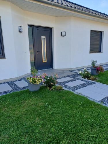 a house with a black door and some flowers at Haus Sonnenwinkel in Walsrode