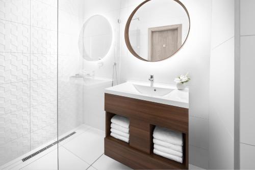 a bathroom with a sink and a mirror at Révay 6 Suites by Corall in Budapest