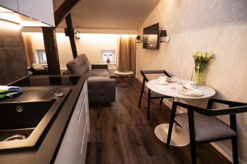 kuchnia i salon ze stołem i krzesłami w obiekcie TS Apartamenty w Bydgoszczy