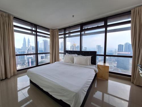 a bedroom with a bed with a view of a city at Best Apartment Suite At Times Square KL in Kuala Lumpur