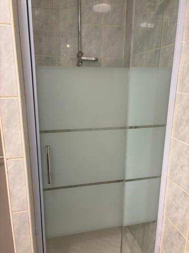 a shower with a glass door in a bathroom at proche de la source in Ouhans
