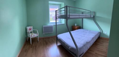 a bedroom with a bunk bed and a chair at proche de la source in Ouhans