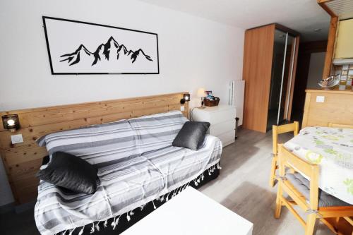 une chambre avec un lit avec une tête de lit en bois dans l'établissement Résidence Soldanelles - Appartement rénové·Proche des pistes·Balcon MAE-0714, à Tignes