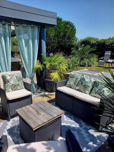 a patio with two chairs and a wooden table at L'appart des mésanges in LʼHerbergement