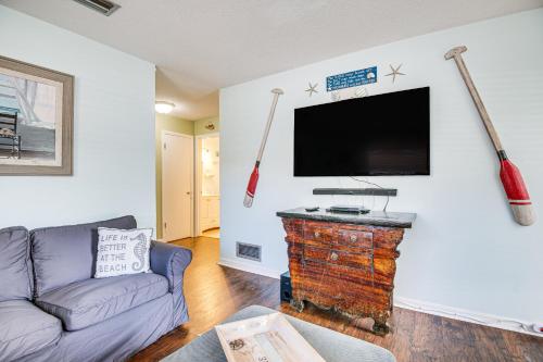 a living room with a couch and a flat screen tv at Cape Canaveral Cottage with Hot Tub Walk to Beach in Cape Canaveral