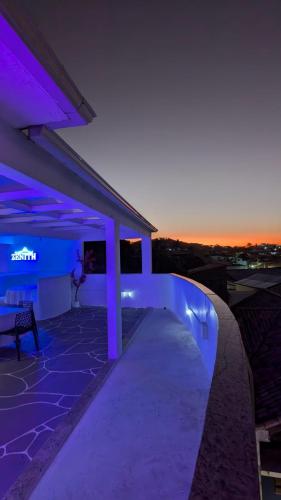 eine nächtliche Aussicht auf ein Haus mit lila Lichtern in der Unterkunft Zenith in Arraial do Cabo