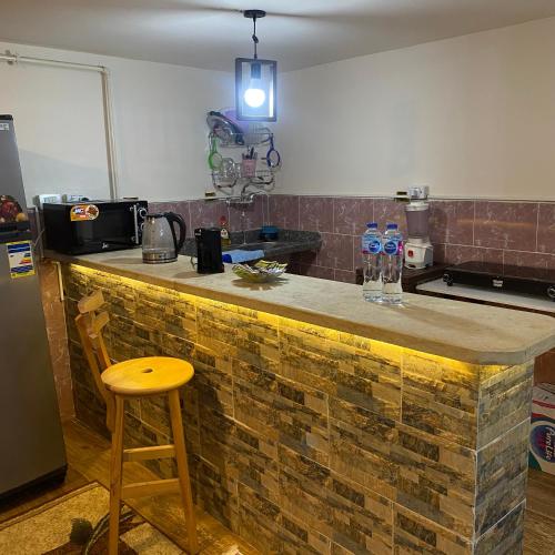 a kitchen with a brick counter with a wooden stool at Studio near airport in Cairo